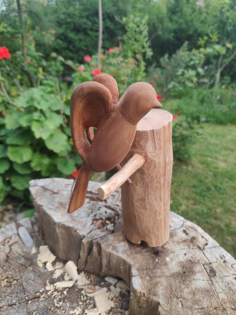 bird made of cedar wood, on white oak stand